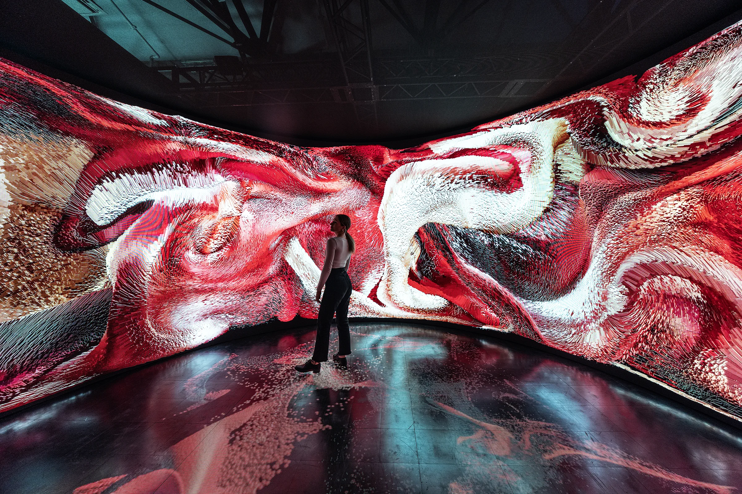 Person standing before a giant curved screen displaying visual elements from The Origin immersive room at Shiseido’s global New Ultimune event.